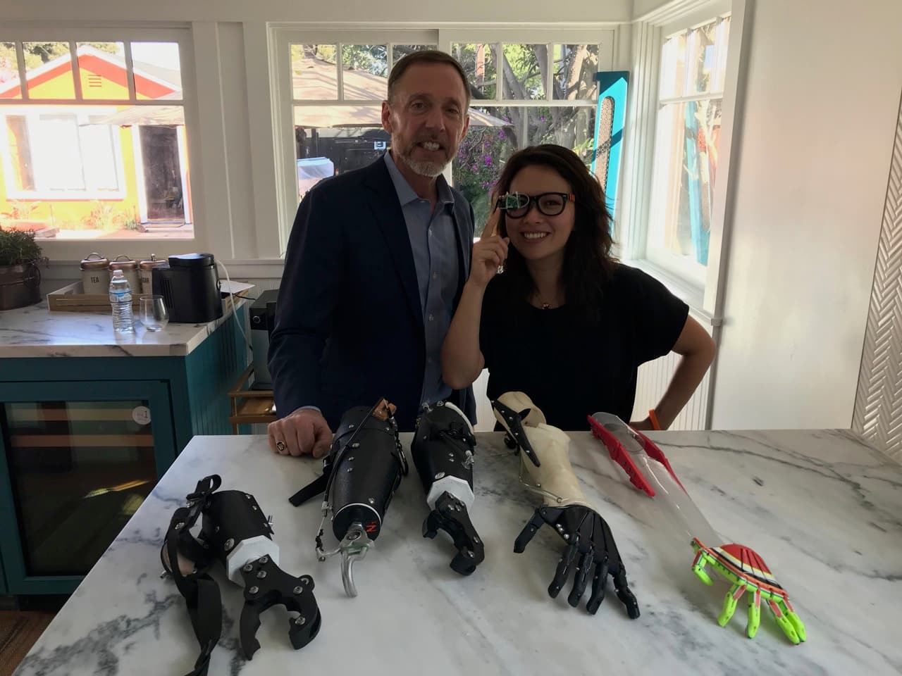 Mick Ebeling showing Fei Wu Not Impossible prosthetic hands
