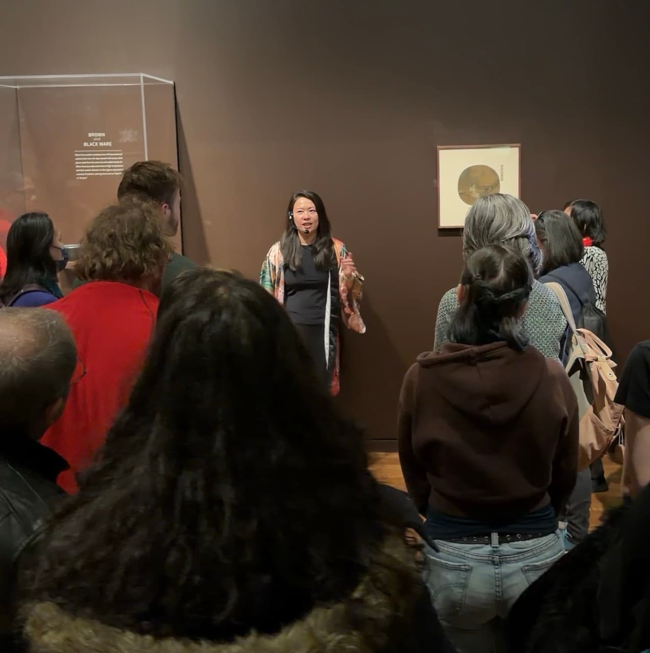 Fei Wu presenting to museum visitors with headset microphone