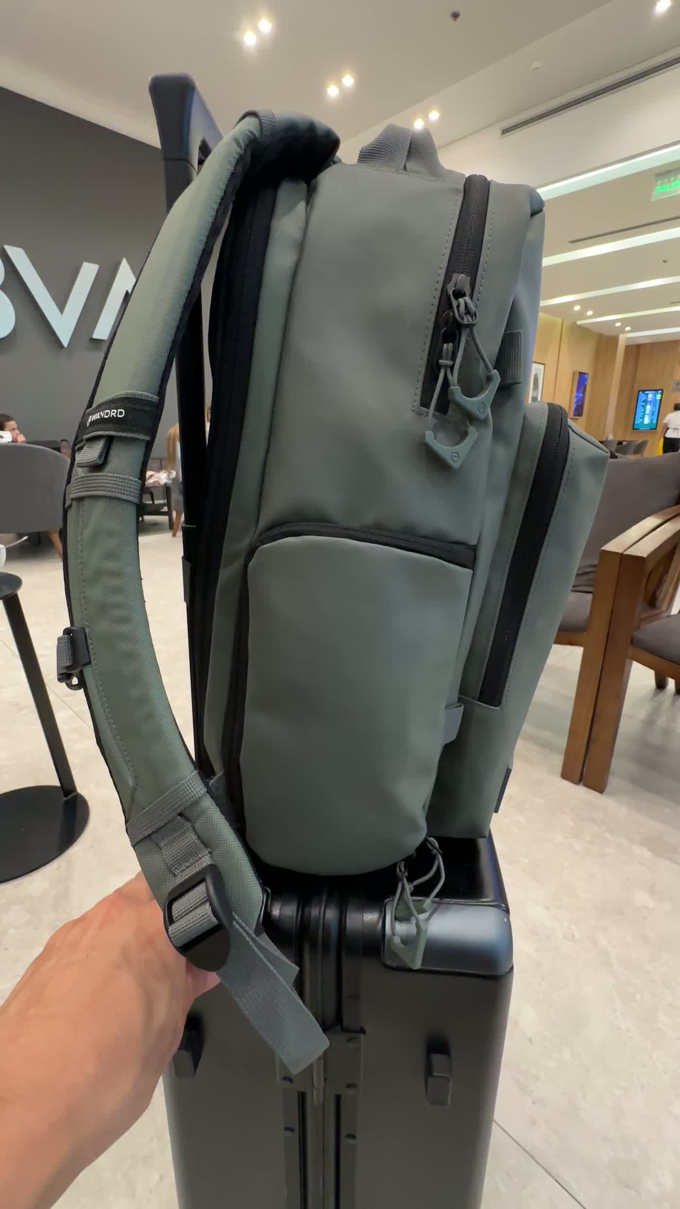 WANDRD PRVKE Pocket 21L luggage passthrough on a rolling suitcase handle